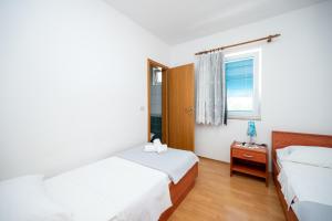 a bedroom with two beds and a window at Apartments by the sea Stara Novalja, Pag - 6301 in Stara Novalja