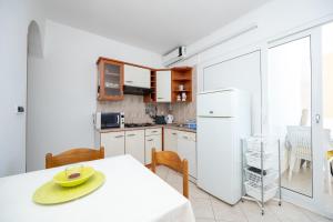 a kitchen with a table with a yellow hat on it at Apartments by the sea Stara Novalja, Pag - 6301 in Stara Novalja