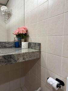 a bathroom with a vase of flowers on a shelf at Flat em Taguatinga in Taguatinga +9 photos