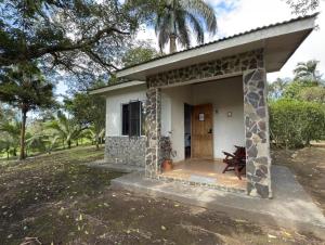 a small house with a porch in a field at Lago Vida Cabins in Tilarán