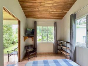 a bedroom with a bed and a large window at Lago Vida Cabins in Tilarán