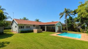 a house with a swimming pool in a yard at Umhlanga La Lucia Oasis, Family Friendly Accommodation in Durban