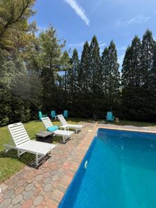 a swimming pool with two lawn chairs next to at Azur East, Southampton in Southampton