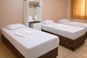 a room with two beds with white sheets at Hotel Benfica in Aparecida +18 photos