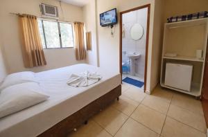 a bedroom with a large bed and a bathroom at Hotel Benfica in Aparecida