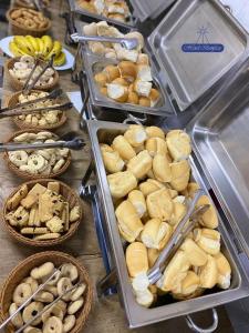 a table topped with trays of bread and other foods at Hotel Benfica in Aparecida