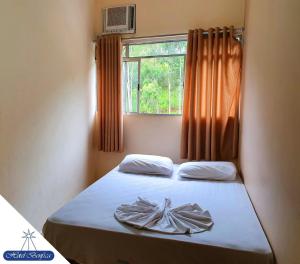a small bedroom with a bed with a window at Hotel Benfica in Aparecida