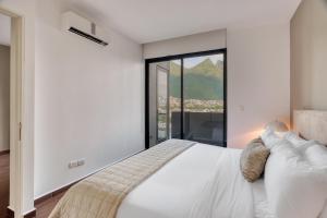a bedroom with a white bed and a large window at Nido x Gran Ciudad Nuevo Sur in Monterrey +71 photos