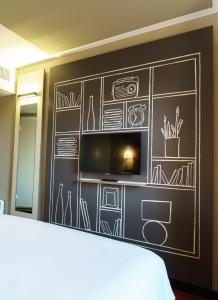 een slaapkamer met een schoolbord en een tv bij ibis Honfleur in Honfleur