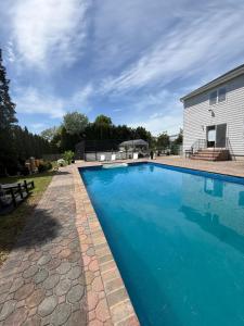 a swimming pool in front of a house at Azur East, Southampton in Southampton +23 photos