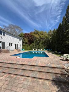a swimming pool in a yard with a brick patio at Azur East, Southampton in Southampton