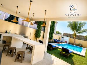 a villa with a swimming pool and a table and chairs at Villa Azucena Monterrico in Monterrico