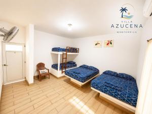 a room with two beds and a chair at Villa Azucena Monterrico in Monterrico