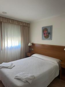 a hotel room with a bed with two towels on it at Hermida Rural in Eirejalba