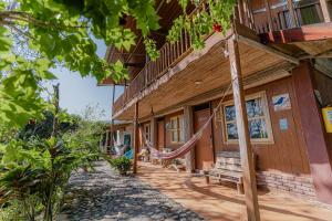 a building with hammocks outside of it at Posada Villa Margarita in Los Naranjos