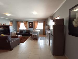 a kitchen and a living room with a refrigerator at Toekies and Abel in Cape Town