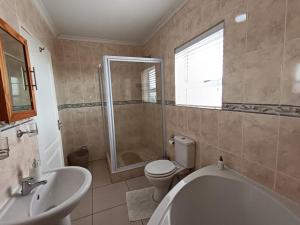 a bathroom with a tub and a toilet and a sink at Toekies and Abel in Cape Town