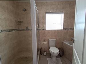 a bathroom with a toilet and a tub and a sink at Toekies and Abel in Cape Town +3 photos