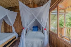 a bedroom with a bed with a mosquito net at Posada Villa Margarita in Los Naranjos
