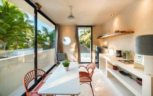 a kitchen with a white table and chairs and a window at Cocuna Boutique Suites La Manzanilla Jalisco in La Manzanilla