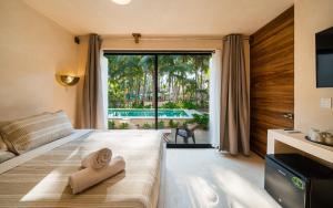 a hotel room with a bed with a towel on it at Cocuna Boutique Suites La Manzanilla Jalisco in La Manzanilla