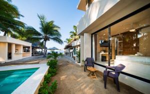 a house with a swimming pool and two chairs next to it at Cocuna Boutique Suites La Manzanilla Jalisco in La Manzanilla