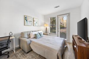 a living room with a bed and a tv at Relaxing Getaway with Pool view & Gym in Frisco