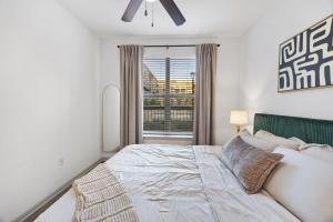 a bedroom with a large bed and a window at Relaxing Getaway with Pool view & Gym in Frisco