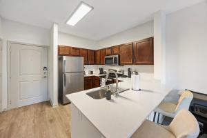 a kitchen with a sink and a refrigerator at Relaxing Getaway with Pool view & Gym in Frisco