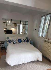 a bedroom with a large white bed with blue pillows at Appartement Chaleureux avec Jardin proximité Métro in Marseille +31 photos