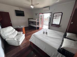 a bedroom with a bed and a chair and a mirror at Hospedaria Campinas in Campinas +12 photos