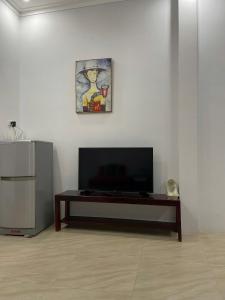a living room with a flat screen tv and a table at Bungalows Hill Mũi Né in Ấp Thiện Long