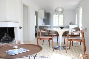a living room with a table and chairs and a fireplace at Das Elchhaus in Saltsjöbaden