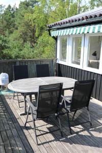 a picnic table and chairs on a deck with a house at Das Elchhaus in Saltsjöbaden +26 photos