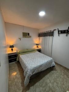 a bedroom with a bed and two tables and a tv at Depto hube in La Banda