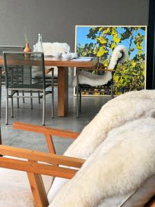 a dining room with a table and chairs and a dining table and a painting at Vinicola Spirito in Espirito Santo Do Pinhal