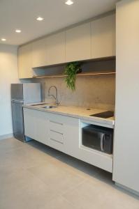 a kitchen with white cabinets and a sink at Studio moderno no coração da Cidade Baixa in Porto Alegre