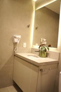 a bathroom with a sink and a mirror at Studio moderno no coração da Cidade Baixa in Porto Alegre
