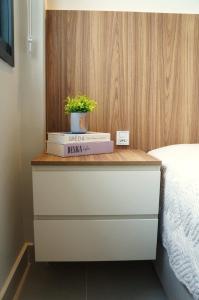 a bedside drawer with a plant on top of it at Studio moderno no coração da Cidade Baixa in Porto Alegre +11 photos