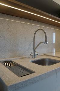 a kitchen sink with a faucet on a counter at Studio moderno no coração da Cidade Baixa in Porto Alegre