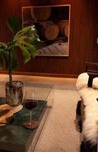 a glass of wine sitting on a table with a plant at Vinicola Spirito in Espirito Santo Do Pinhal +13 photos