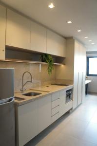 a kitchen with white cabinets and a sink at Studio moderno no coração da Cidade Baixa in Porto Alegre