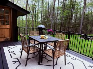 a black table and chairs on a deck at Modern Designed Cabin with Secluded Backyard Firepit Grill Nintendo Switch2 in Gouldsboro