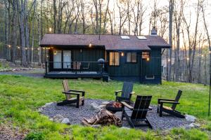 a cabin with chairs and a fire pit in front of it at Modern Designed Cabin with Secluded Backyard Firepit Grill Nintendo Switch2 in Gouldsboro