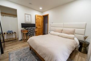a bedroom with a large white bed and a desk at Modern Designed Cabin with Secluded Backyard Firepit Grill Nintendo Switch2 in Gouldsboro