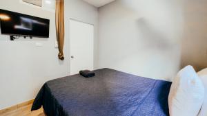a bedroom with a bed and a flat screen tv at Villa Verona in Guatemala