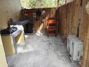 a kitchen with a sink and a wooden fence at the bamboo Bali Cabin in Nusa Dua