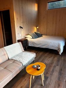 a room with two beds and a couch and a table at Piedra Amarilla Tiny House in Curanipe
