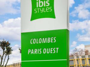 a green and white sign for colombias pants outpost at ibis Styles Colombes Paris Ouest (Ouverture Octobre 2025) in Colombes