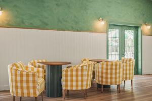 a dining room with two tables and yellow chairs at Petit Cowboy in New Braunfels